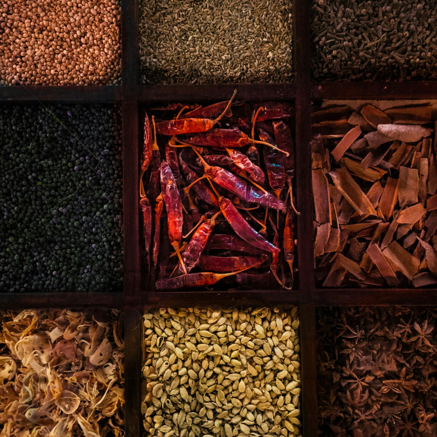 A vibrant collection of assorted spices in wooden boxes highlighting variety and color.